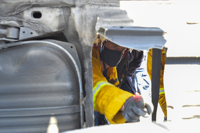 Firefighter Works to Access "Victim" through Bottom of Car