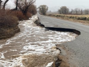 Photo from Inyo County of an flood stream taking out a road.