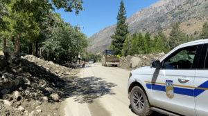 A Cal OES truck drives through a cleared road in a San Bernardino County mountain community