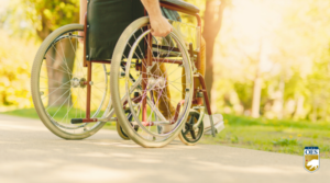 image of a wheelchair showing persons hands on the wheels. Sunny outdoor background. There is a Cal O E S logo in the bottom right corner.