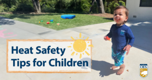 child with frozen treat. blue outfit and grass behind him.