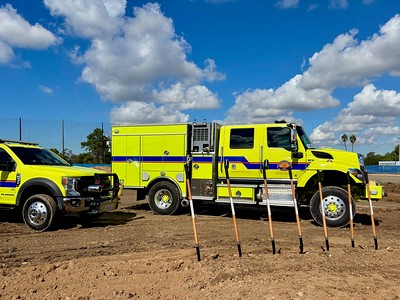 Fire trucks with seven shovels in the foreground.