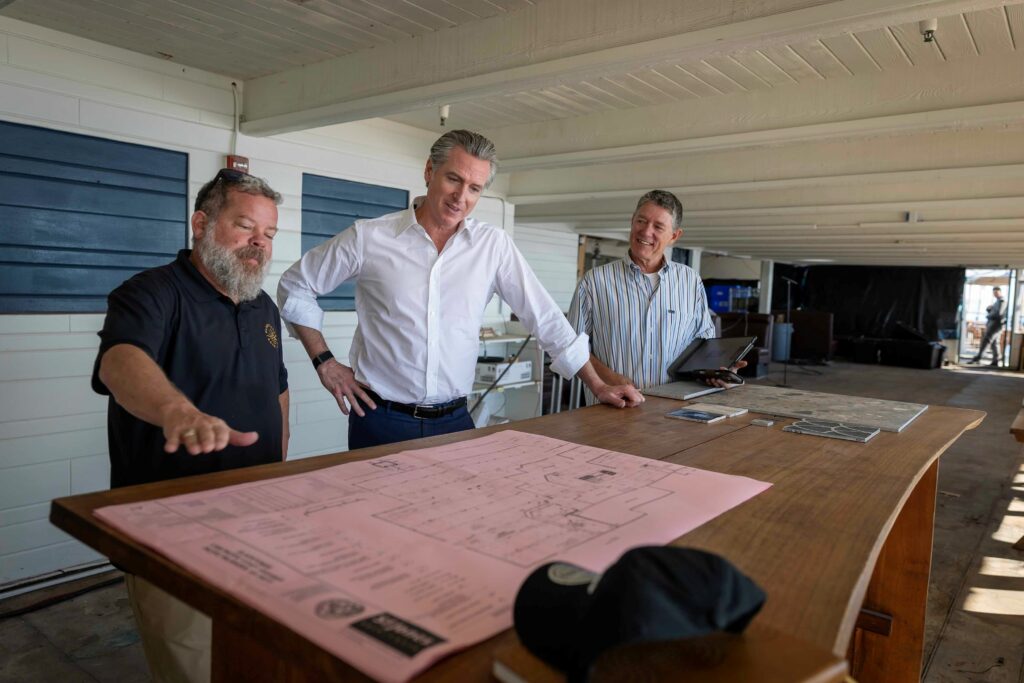Governor newsom looking at a plan on a table
