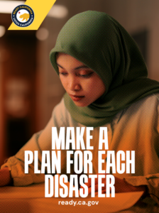 A woman wearing a green hijab sits at a desk looking at papers.